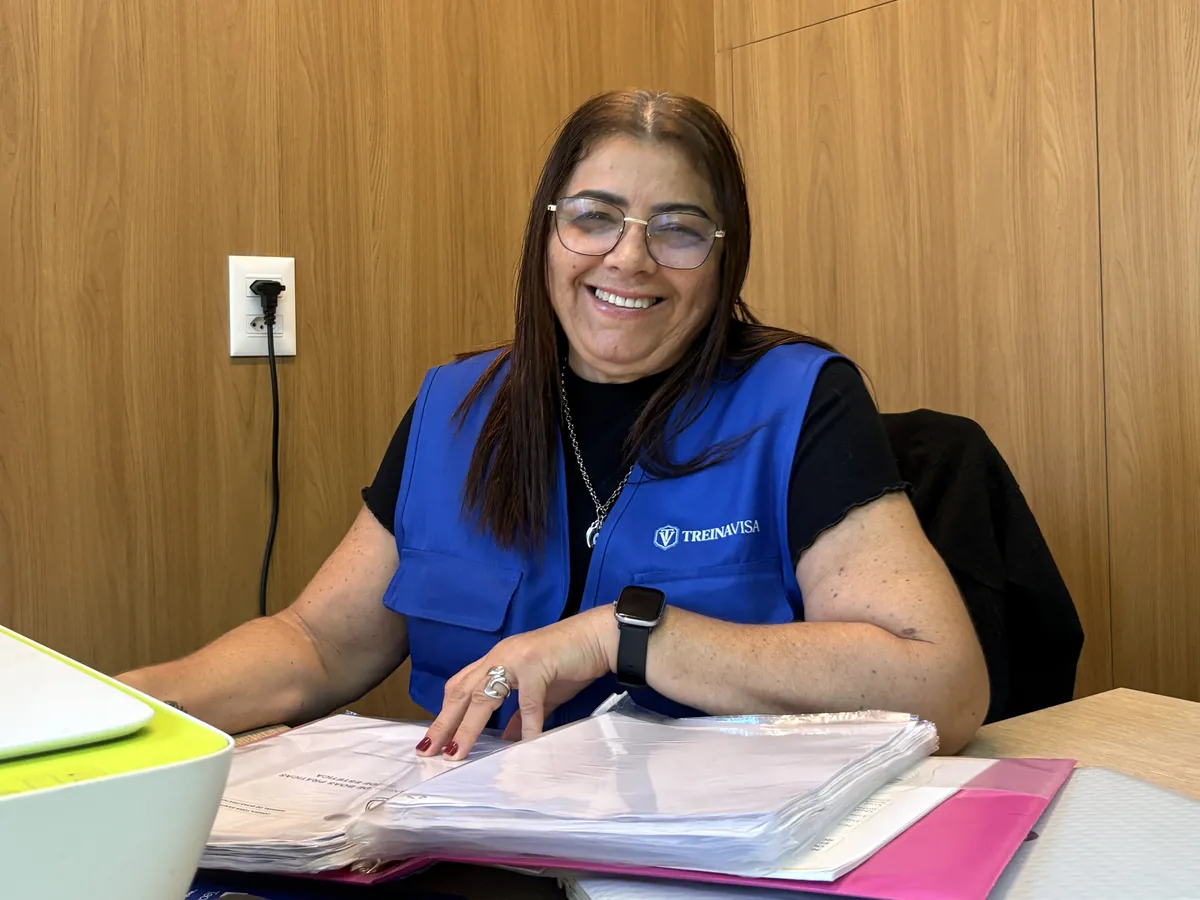 Ana Roberta, de colete da TreinaVISA, revisando uma pasta sanitária